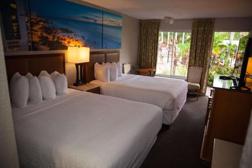 um quarto de hotel com duas camas e uma janela em Days Inn by Wyndham Cocoa Cruiseport West At I-95/524 em Cocoa