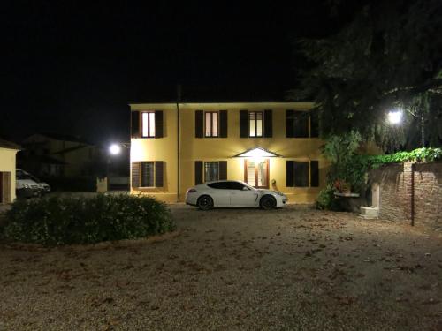 a white car parked in front of a house at night at Villa Schiavi in Sermide