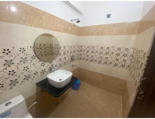 a bathroom with a sink and a toilet and a mirror at Shivalik Residency, Obaree, UP in Bāra Banki