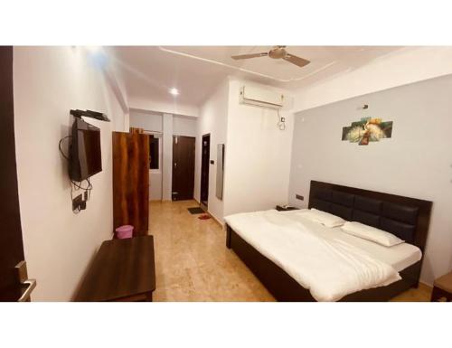 a bedroom with a bed and a flat screen tv at Shivalik Residency, Obaree, UP in Bāra Banki
