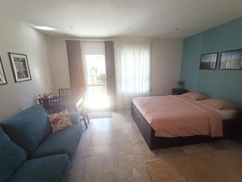 een slaapkamer met een bed, een bank en een raam bij Appartement Torremolinos Dona Carlota in Torremolinos