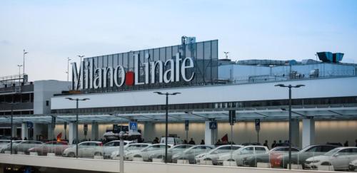 a parking lot with cars parked in front of a large building at ROYAL MILANO LINATE APARTMENTS in Pantigliate