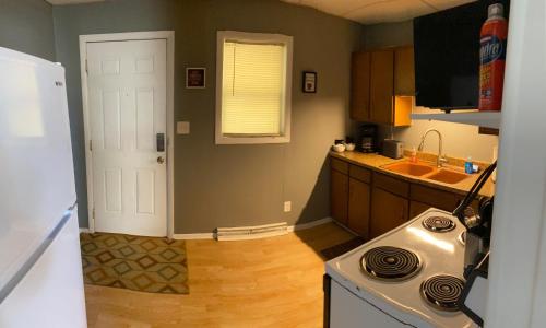 a kitchen with a white door and a stove at Downtown Getaway in Michigan City