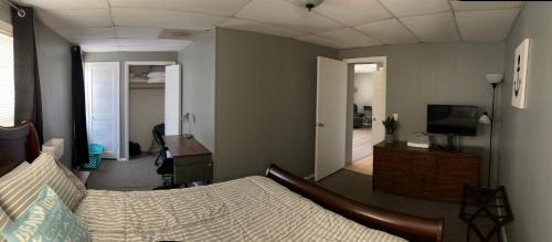 Schlafzimmer mit einem Bett, einem Schreibtisch und einem TV in der Unterkunft Downtown Getaway in Michigan City