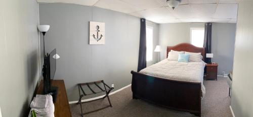 a bedroom with a bed and a chair in it at Downtown Getaway in Michigan City