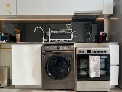 a kitchen with a washing machine and a dishwasher at Al Reem Skyline 1BR - Stylish Luxe Retreat in Abu Dhabi