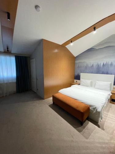 um quarto com uma cama grande e um quadro na parede em The Mirror Hotel em Baku