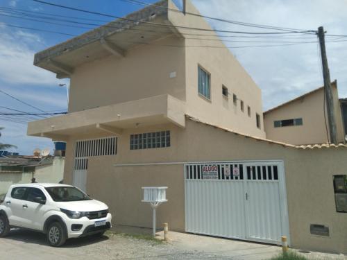 a white car parked in front of a house at Casa Pé na Areia Monte Alto Arraial do Cabo RJ in Arraial do Cabo