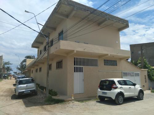 two cars parked in front of a house at Casa Pé na Areia Monte Alto Arraial do Cabo RJ in Arraial do Cabo