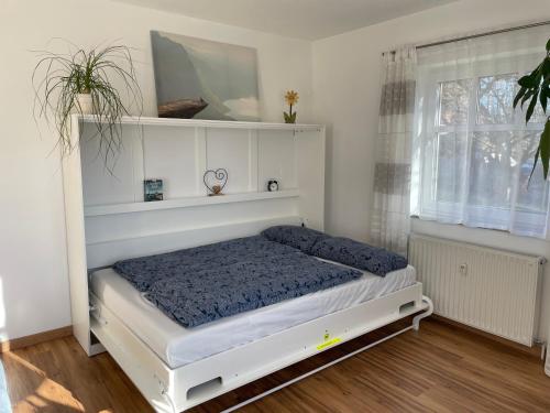 białe łóżko w pokoju z oknem w obiekcie Idyllische Ferienwohnung zum Wohlfühlen+Entspannen w mieście Lichtenstein