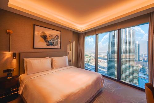 a bedroom with a large bed and a large window at THE CLOSEST building to Burj Khalifa with Fountain View in Address Opera Residence in Dubai