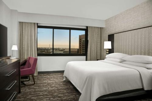 a hotel room with a large bed and a window at Embassy Suites by Hilton Crystal City National Airport in Arlington