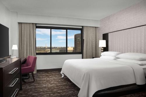 a hotel room with a bed and a large window at Embassy Suites by Hilton Crystal City National Airport in Arlington