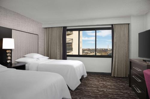 a hotel room with two beds and a window at Embassy Suites by Hilton Crystal City National Airport in Arlington