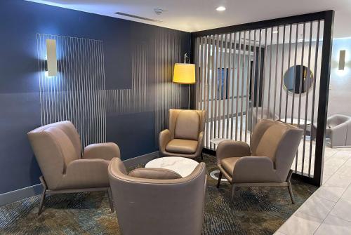 a waiting room with chairs and a table and a mirror at La Quinta by Wyndham South Bend in South Bend