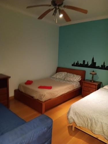 a bedroom with two beds and a ceiling fan at Global Guest in Sintra