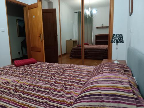 a bedroom with a bed with a colorful blanket on it at Global Guest in Sintra