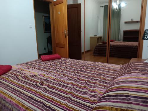 a bedroom with a bed with a colorful blanket at Global Guest in Sintra