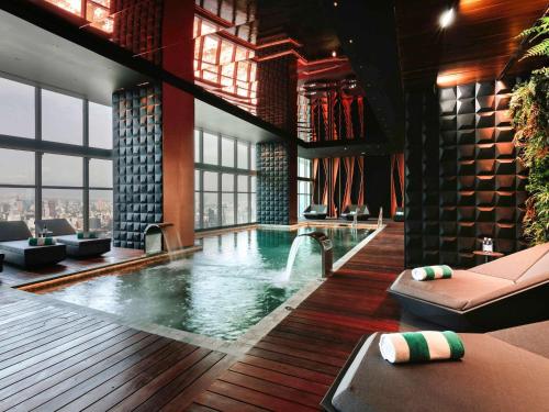 a swimming pool in a hotel with chairs and tables at Sofitel Mexico City Reforma in Mexico City