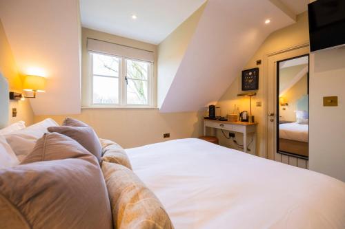 Un dormitorio con una gran cama blanca y una ventana en The Bottle & Glass Inn - Barn View - Room 2, en Henley on Thames