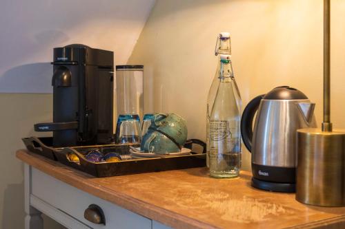 a counter with a coffee maker and a bottle on it at The Bottle & Glass Inn - Barn View - Room 2 in Henley on Thames