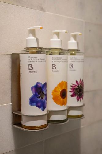 a group of four bottles of moisturizers on a shelf at The Bottle & Glass Inn - Barn View - Room 2 in Henley on Thames