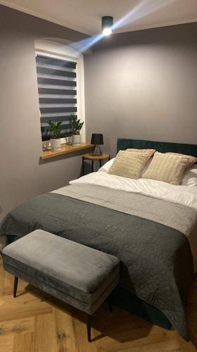 um quarto com uma cama grande e uma janela em Apartament Rose Valley Dwa Zero em Szczytna