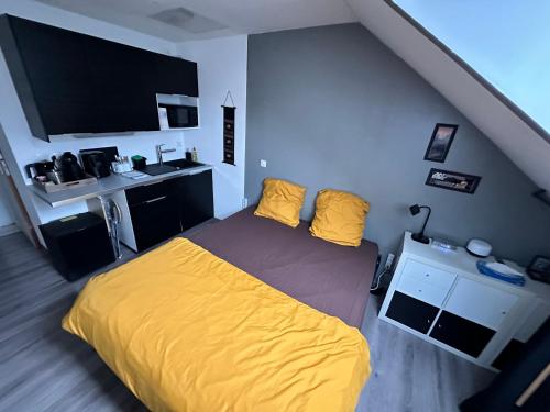 una camera con letto giallo e lavandino di NID DOUILLET INDEPENDANT a La Ferté-Alais
