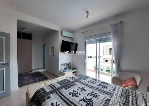 a bedroom with a bed and a large window at Lindo aconchego do Interior. in Sorocaba