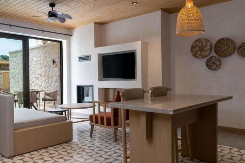 a living room with a table and a tv at Radisson Blu Hotel, Kas in Kas