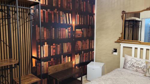 une chambre avec un mur rempli de livres dans l'établissement "Da Nina", à Lascari