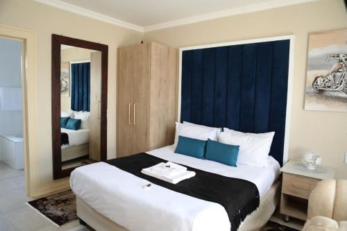 a hotel room with a large bed with a mirror at The Edge Lodge in Polokwane