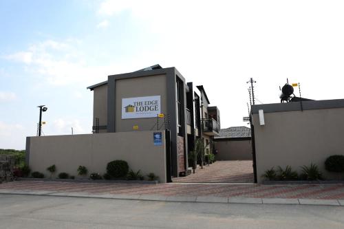 a building with a sign that reads wild dog house at The Edge Lodge in Polokwane