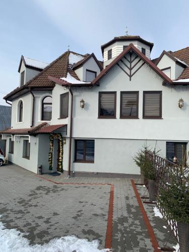 a white house with a driveway in front of it at Casa Lazar in Topliţa