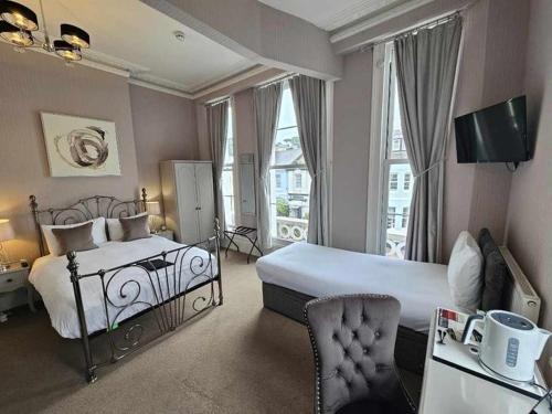a bedroom with a large bed and a large window at The Rosewood Torquay in Torquay
