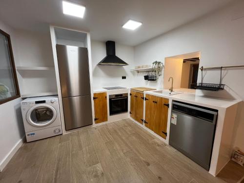 a kitchen with a refrigerator and a washer and dryer at Casa Rural Hoyo del moro in Liétor