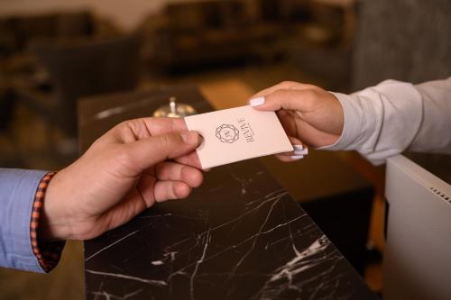 a person handing another person a piece of paper at Revive Boutique Hotel in Yerevan