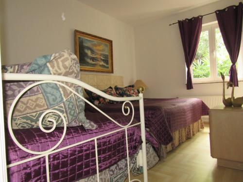 a bedroom with a bed with a purple blanket at Villa Palme 1 in Opatija