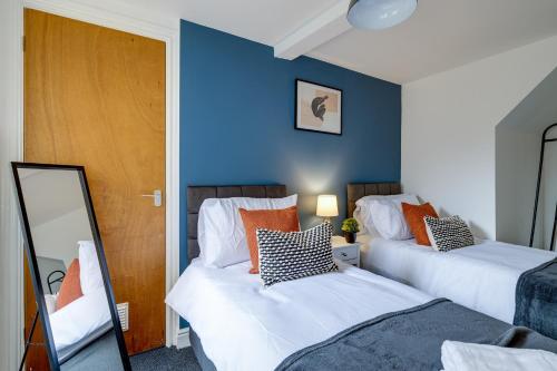 Queens Cabin - Near South Bay Beach في سكرابورو: سريرين في غرفة بجدران زرقاء ومرآة