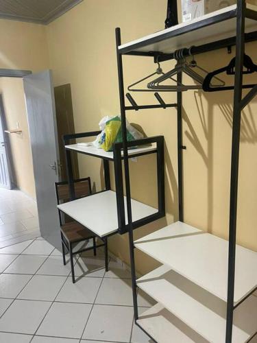 Zimmer mit einem Regal, einem Tisch und einem Stuhl in der Unterkunft Ap completo otimo local proximo shopping 2 in Campo Grande