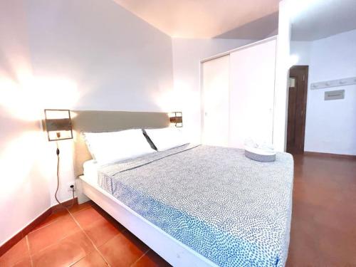 a white bedroom with a bed with a lamp on it at Porto Antigo 2- lovely studio 32 in Santa Maria