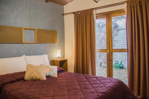a bedroom with a large bed and a window at Finca La Pichona in Los Árboles