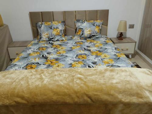 a bedroom with a bed with blue and yellow flowers at Résidence djerba 4 in Houmt Souk