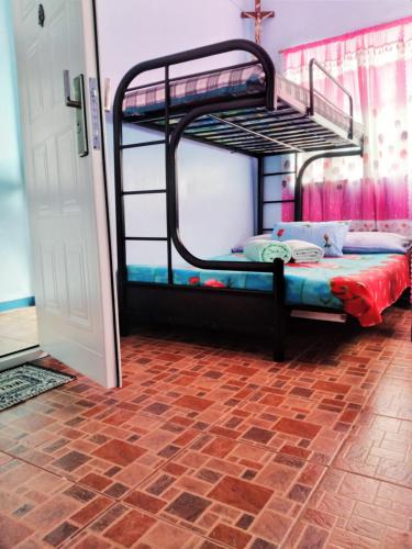 two bunk beds in a room with a brick floor at ARSIAM Transient Room in Baguio