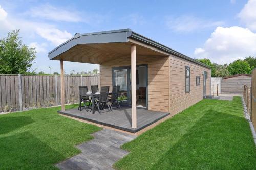 a gazebo with a table and chairs in a yard at Chalet de Strandgaper - Ouddorp in Ouddorp
