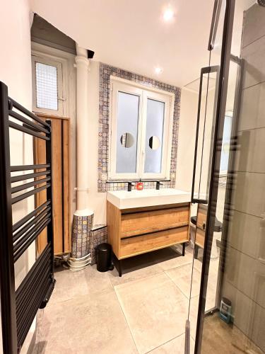 une salle de bain avec un lavabo et une fenêtre dans l'établissement Charming 4-room flat near Eiffel Tower-8people-2 bedrooms, à Paris