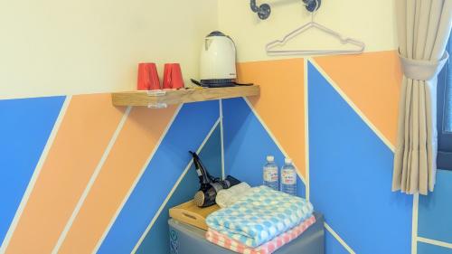Zimmer mit einer bemalten Wand, einem Tisch und einem Bett in der Unterkunft 澐河民宿 in Lien-shih