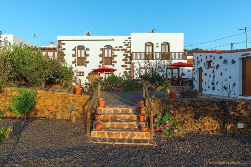 una casa con una pared de piedra y escaleras delante en Las Casas del Abuelito Julián & la Abuela Leonor, en Isora