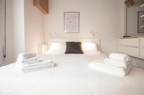 een slaapkamer met een wit bed en handdoeken bij Bologna Easy Explore - AmbrogioHost in Bologna