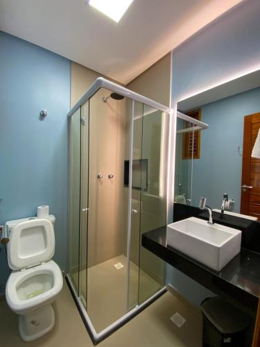 a bathroom with a toilet and a sink at Villa Palmeira Flecheiras 101 in Flecheiras
